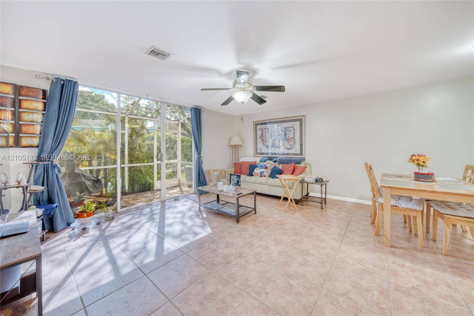 Expansive screened patio access, ceiling fan with integrated lighting, recessed lighting, and tile flooring