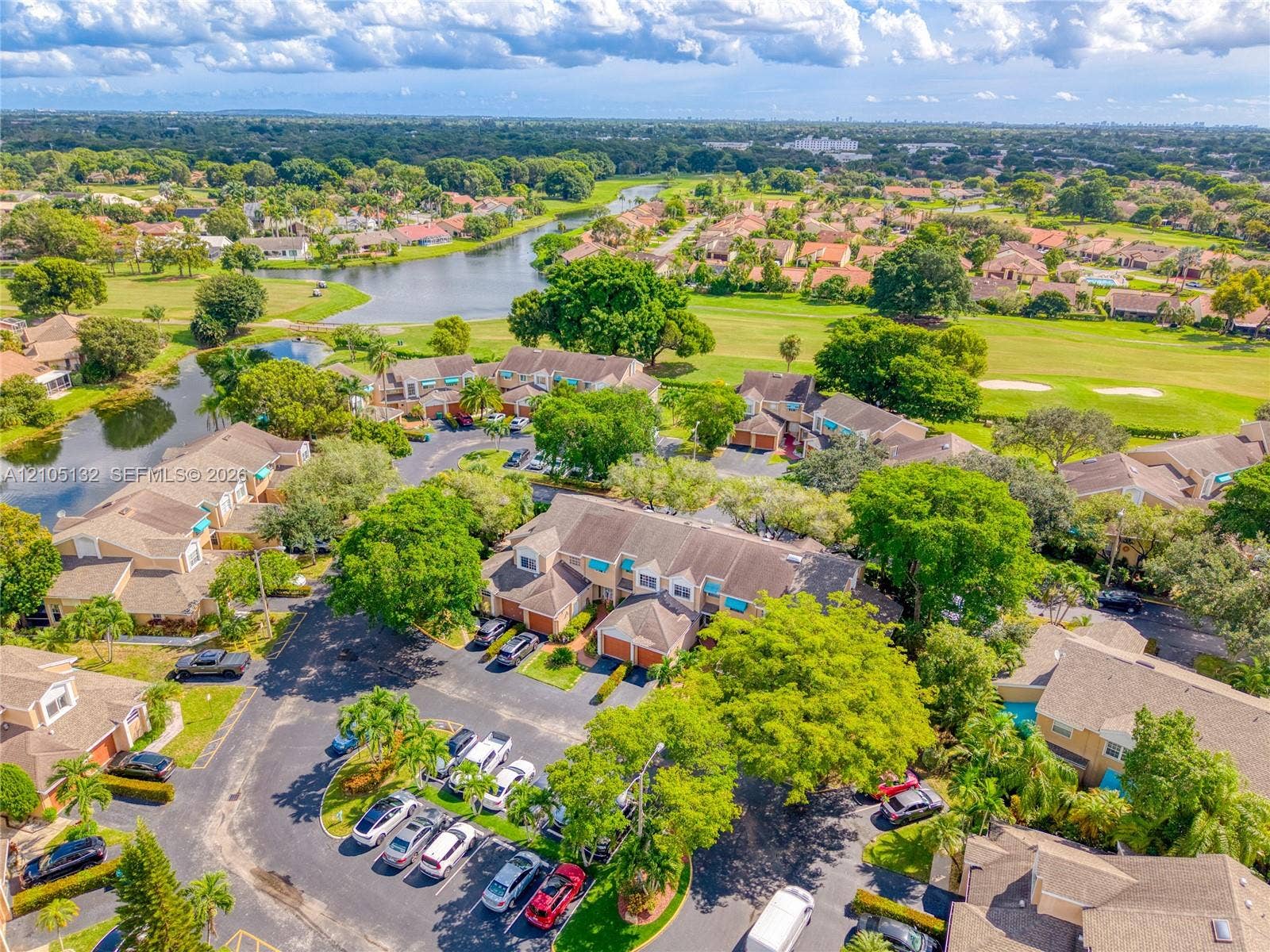 Community featuring a golf course, expansive water features, and abundant mature landscaping