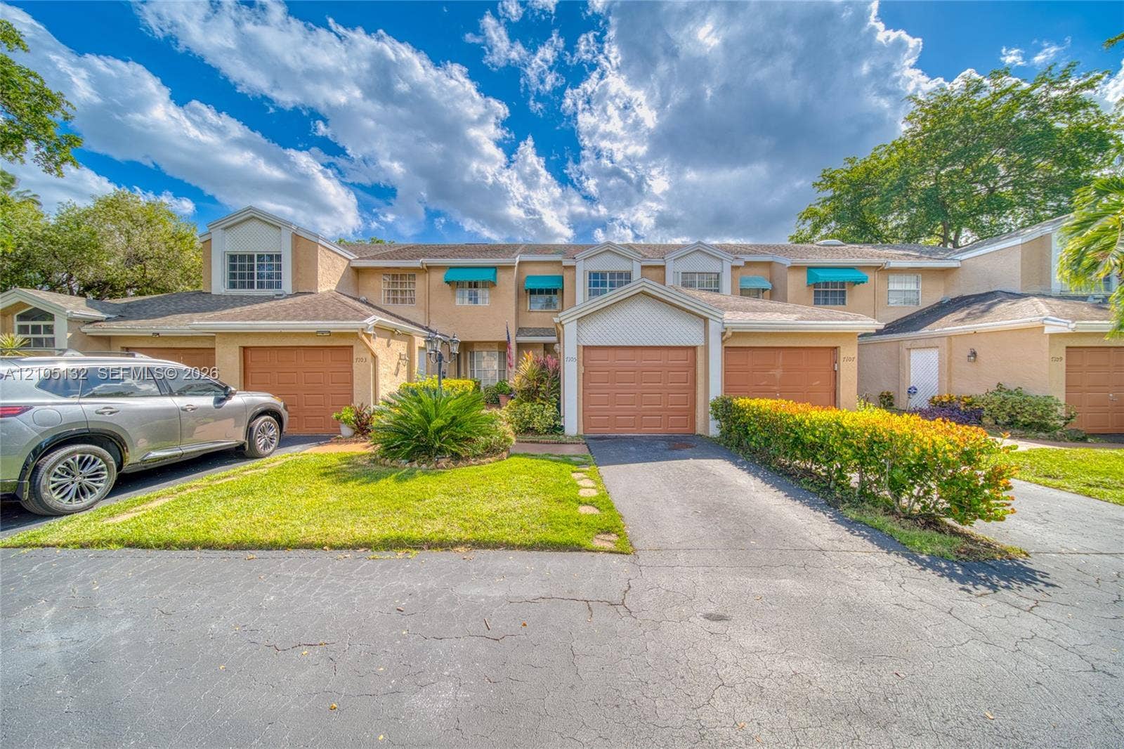 Multi-story stucco exterior with attached garages and paved driveways