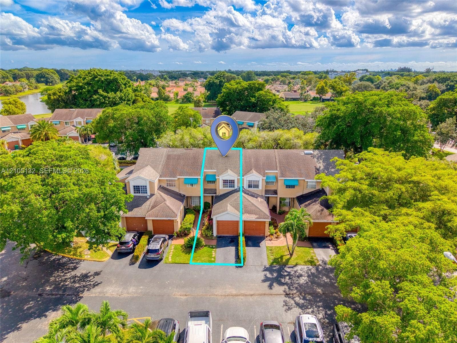 Townhome with a single-car garage, established landscaping, and awnings