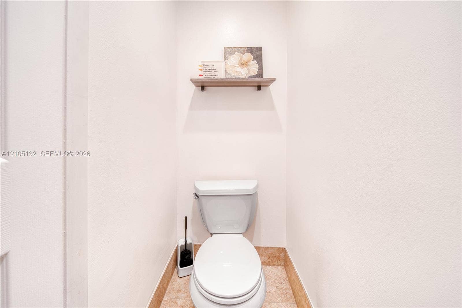 Built-in wall niche with wood-finish shelving above a commode