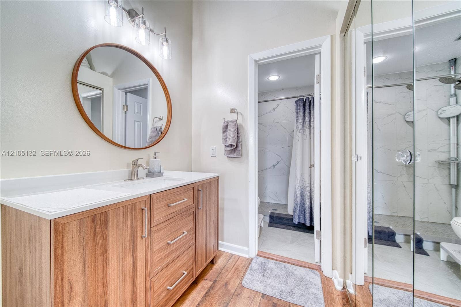 Wood-finish flooring with a vanity featuring a light-toned countertop