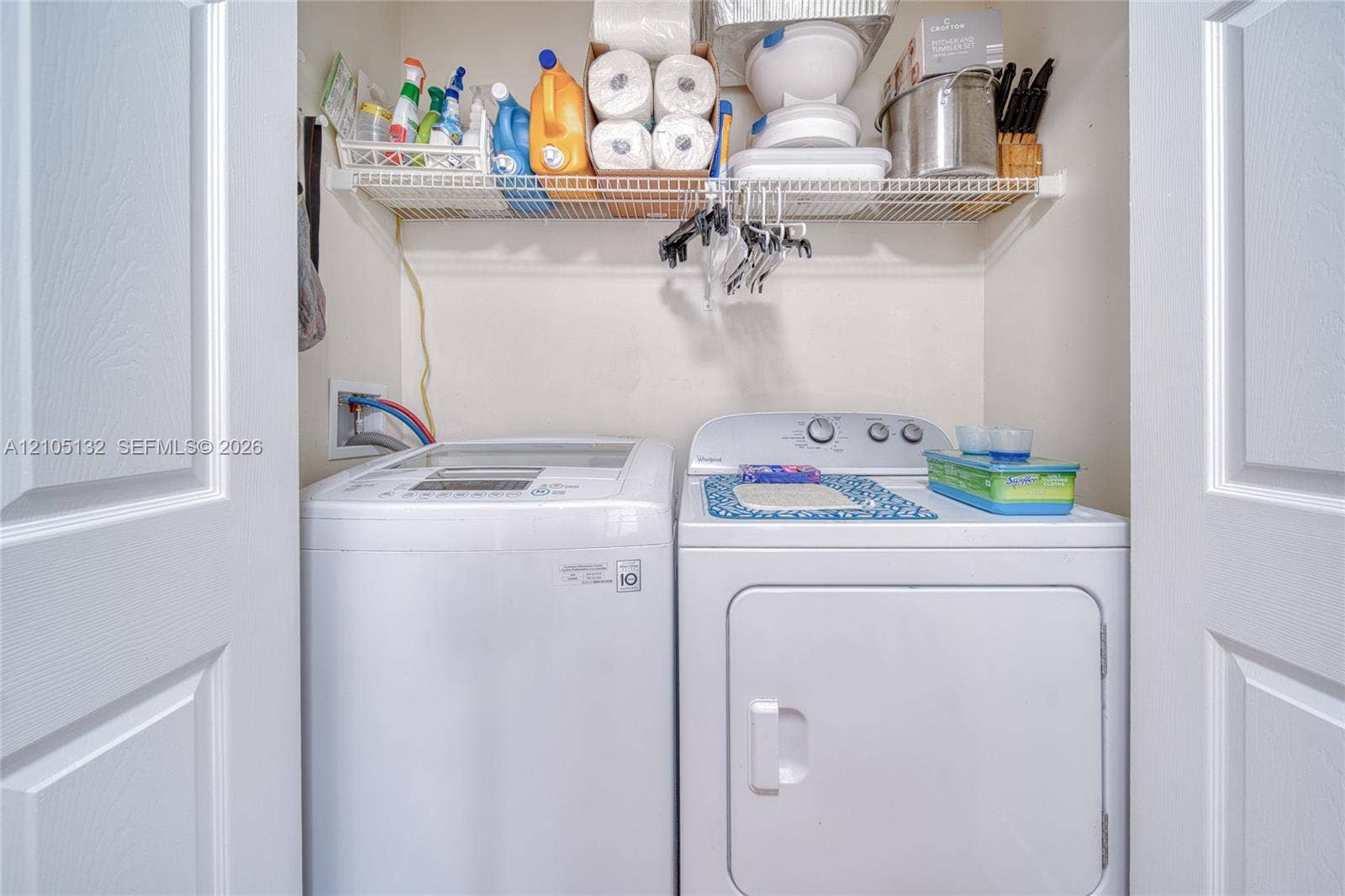 Laundry closet featuring a washer, dryer, and wire shelving