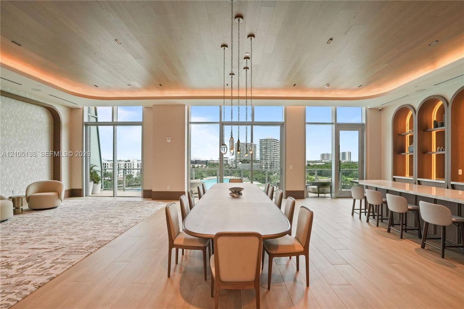 2411 Laguna Circle, #1505, North Miami, FL 33181 Expansive room featuring wood-finish flooring, a full wall of floor-to-ceiling windows, built-in shelving with arched accents, and recessed ceiling lighting