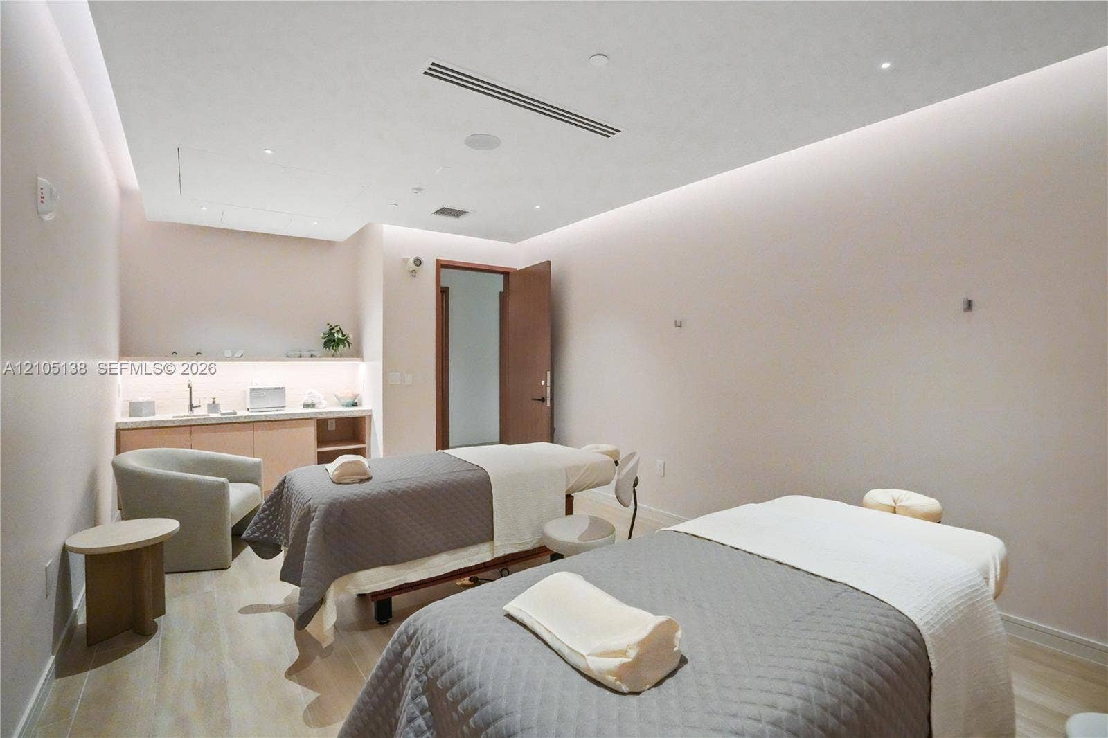 2411 Laguna Circle, #1505, North Miami, FL 33181 Two treatment tables, recessed ceiling lighting, wood-finish flooring, built-in cabinetry with sink, and a solid core door
