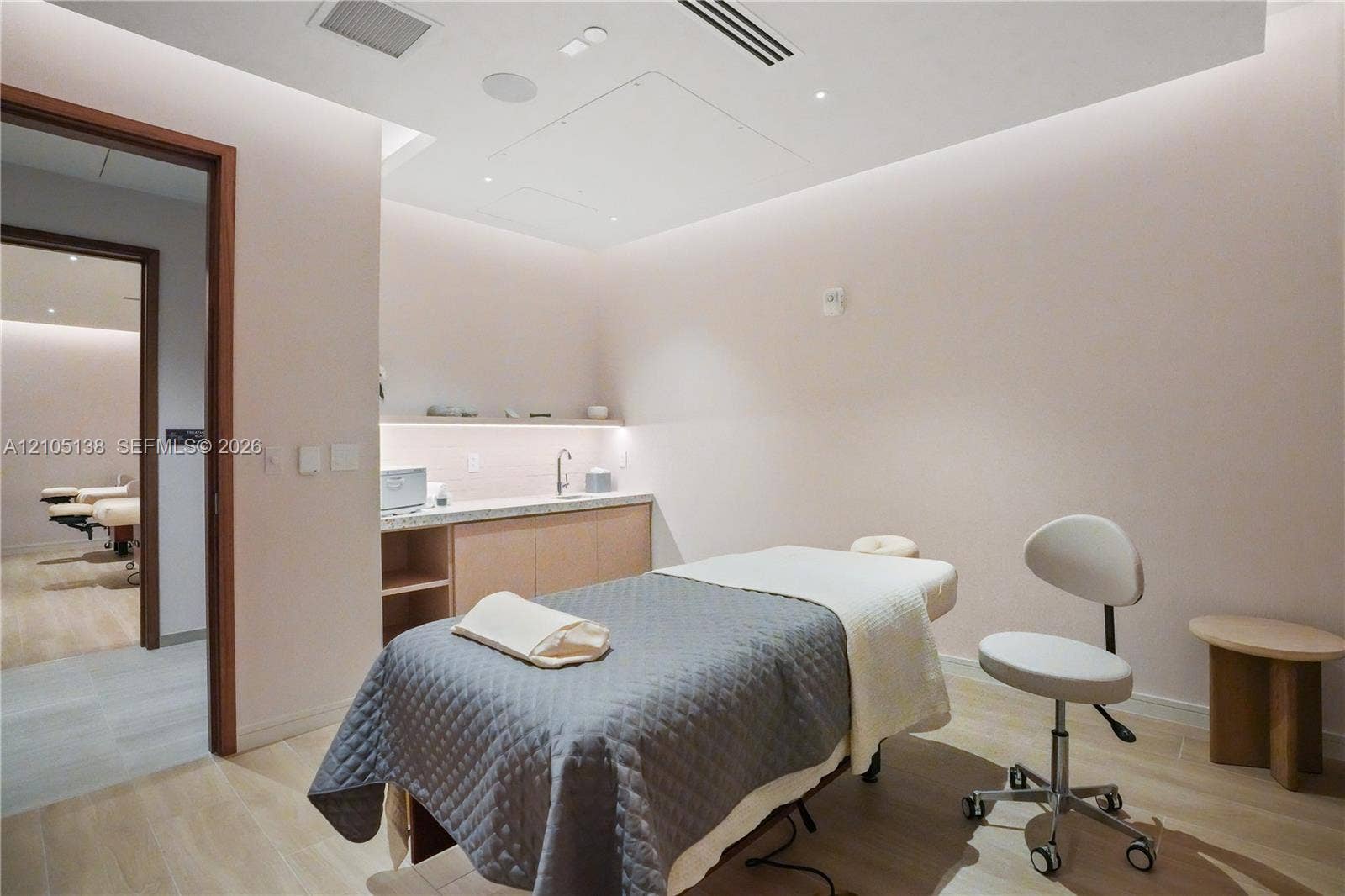 2411 Laguna Circle, #1505, North Miami, FL 33181 Integrated lighting within ceiling soffit, wood-finish flooring, built-in cabinetry, and a countertop with an undermount sink