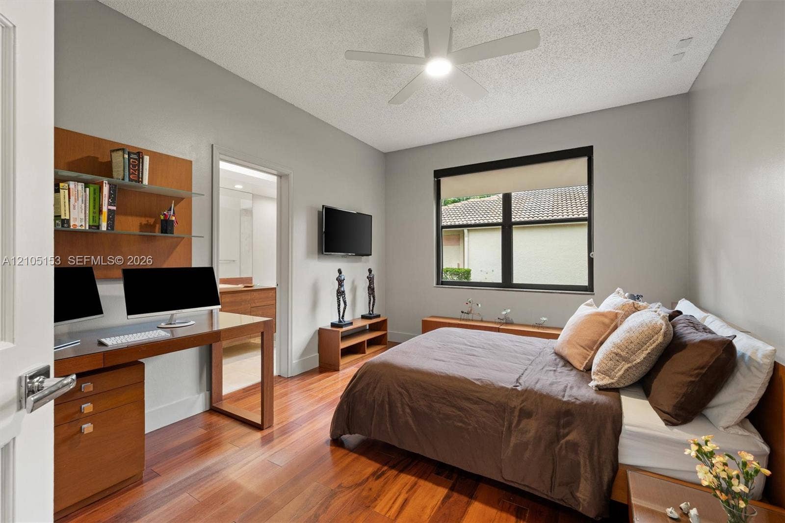 Hardwood flooring, recessed lighting, built-in shelving, ceiling fan, and an interior door