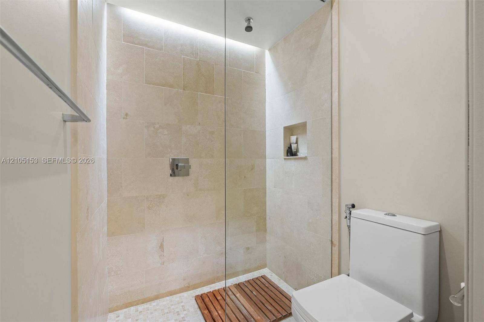 Shower with tiled walls, recessed niche, and clear glass enclosure