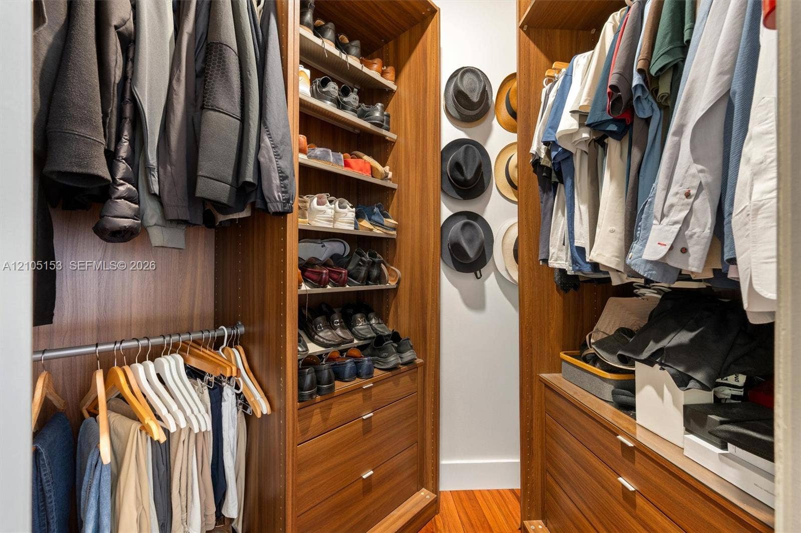 Custom closet system featuring wood-finish cabinetry, integrated shelving, and multiple hanging rods