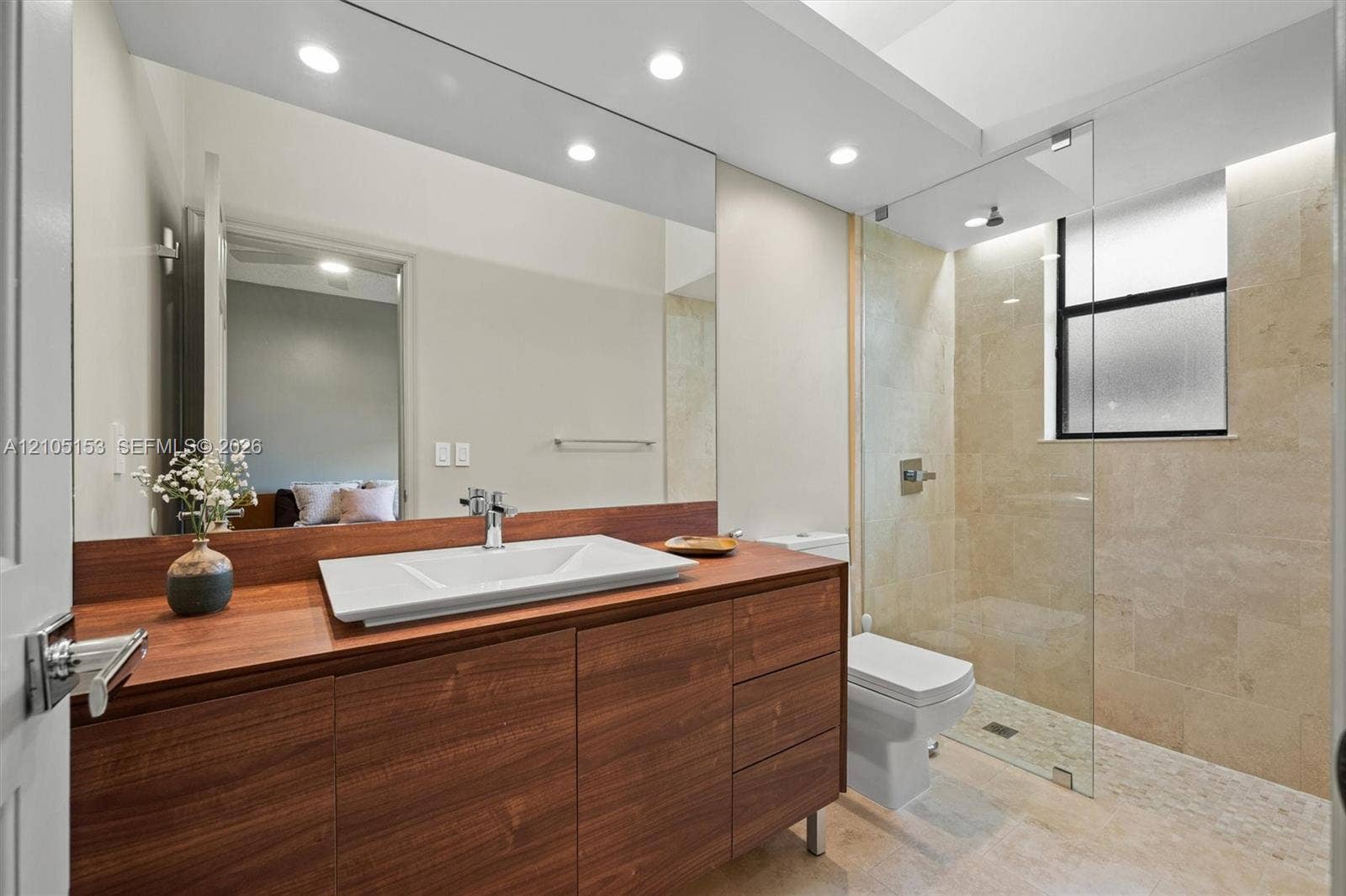 Floating wood-finish vanity with a vessel sink and chrome faucet