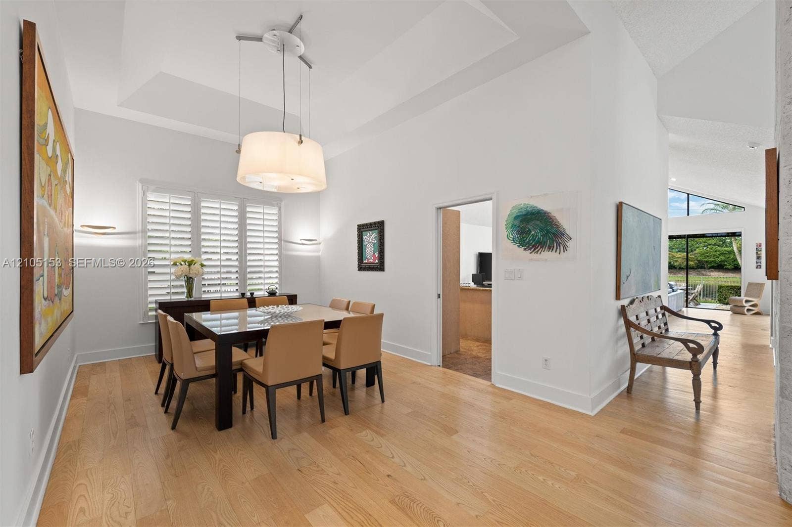 Wood-finish flooring throughout, featuring a tray ceiling, recessed lighting, and plantation shutters