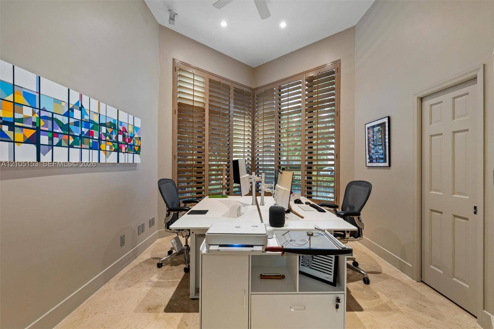 Vaulted ceiling with recessed lighting, wood-finish plantation shutters, paneled door, and tile flooring