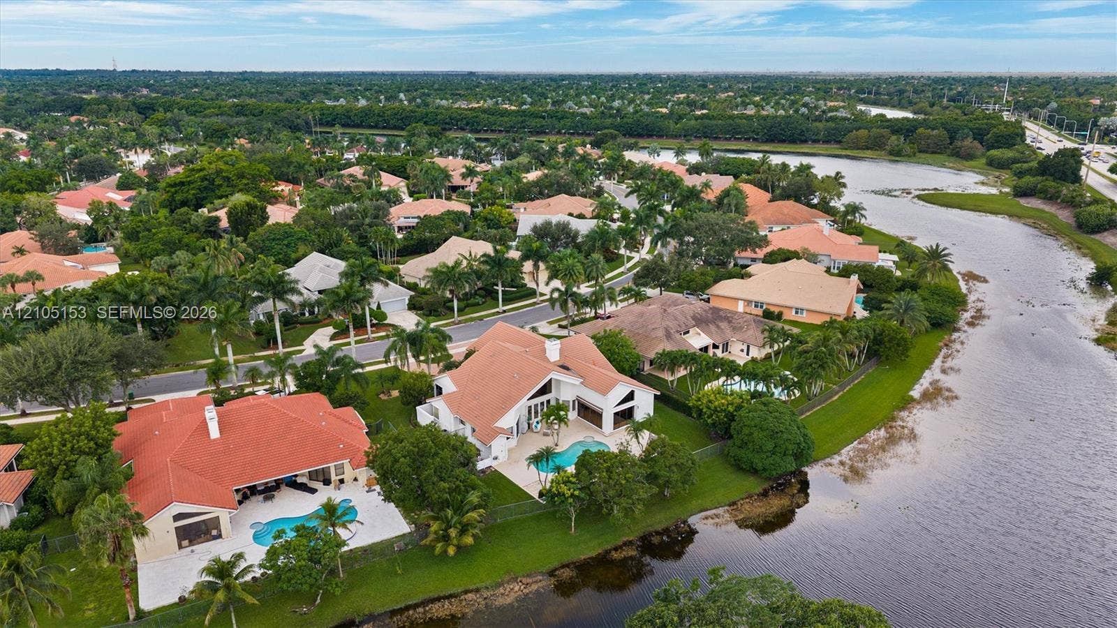 Property with red tile roofing, a swimming pool, and a paved patio area
