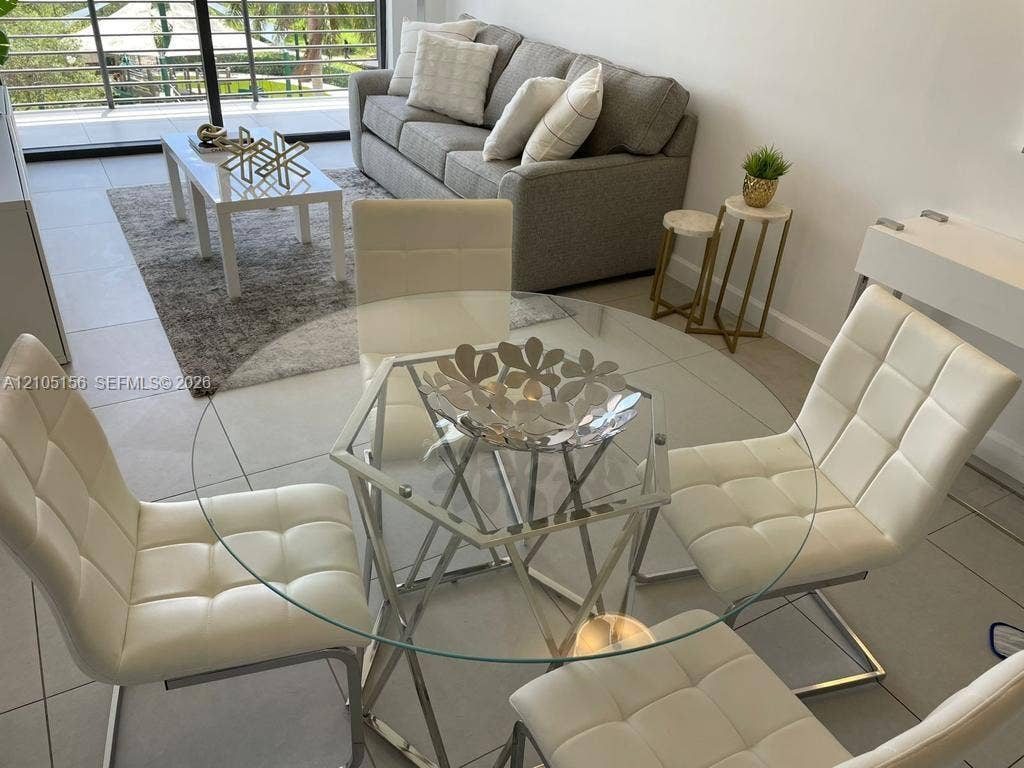 5350 NW 84th Avenue, #303, Doral, FL 33166 Large-format tile flooring, neutral wall palette, and sliding glass door with balcony access