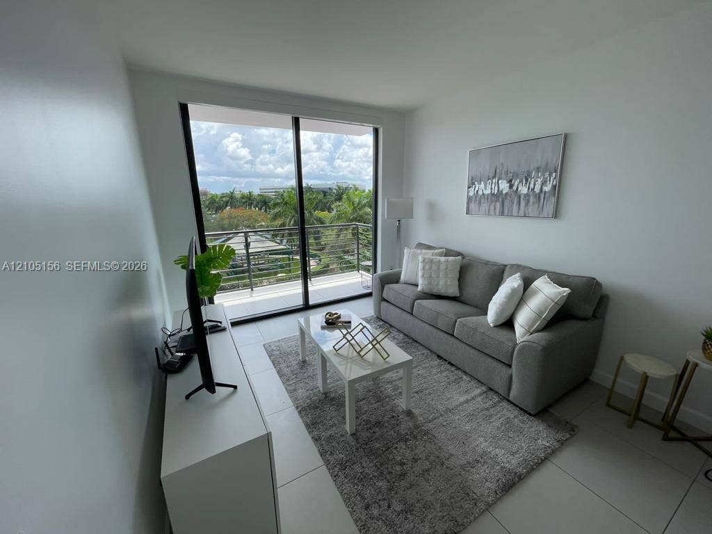 5350 NW 84th Avenue, #303, Doral, FL 33166 Floor-to-ceiling sliding glass doors, neutral tile flooring, and private balcony with horizontal railing