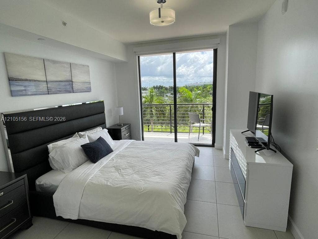 5350 NW 84th Avenue, #303, Doral, FL 33166 Large-format tile flooring, recessed ceiling lighting, and floor-to-ceiling glass sliding doors opening to a balcony with a metal railing