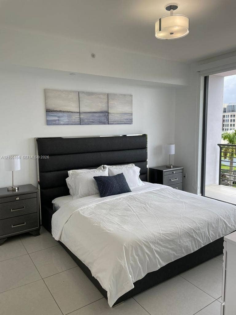 5350 NW 84th Avenue, #303, Doral, FL 33166 Large-format tile flooring, drum-style ceiling light fixture, and floor-to-ceiling glass door leading to a private balcony