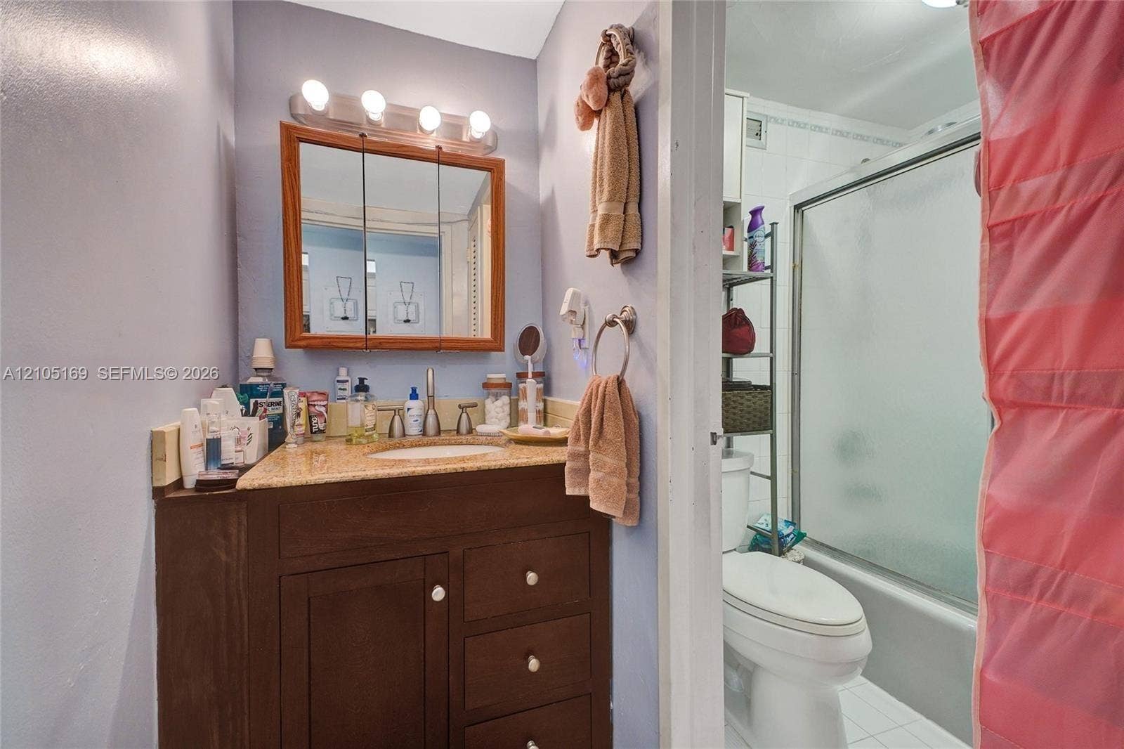 2899 Collins Avenue, #521, Miami Beach, FL 33140 Bathroom featuring a wood-finish vanity with an integrated sink and light-toned countertop