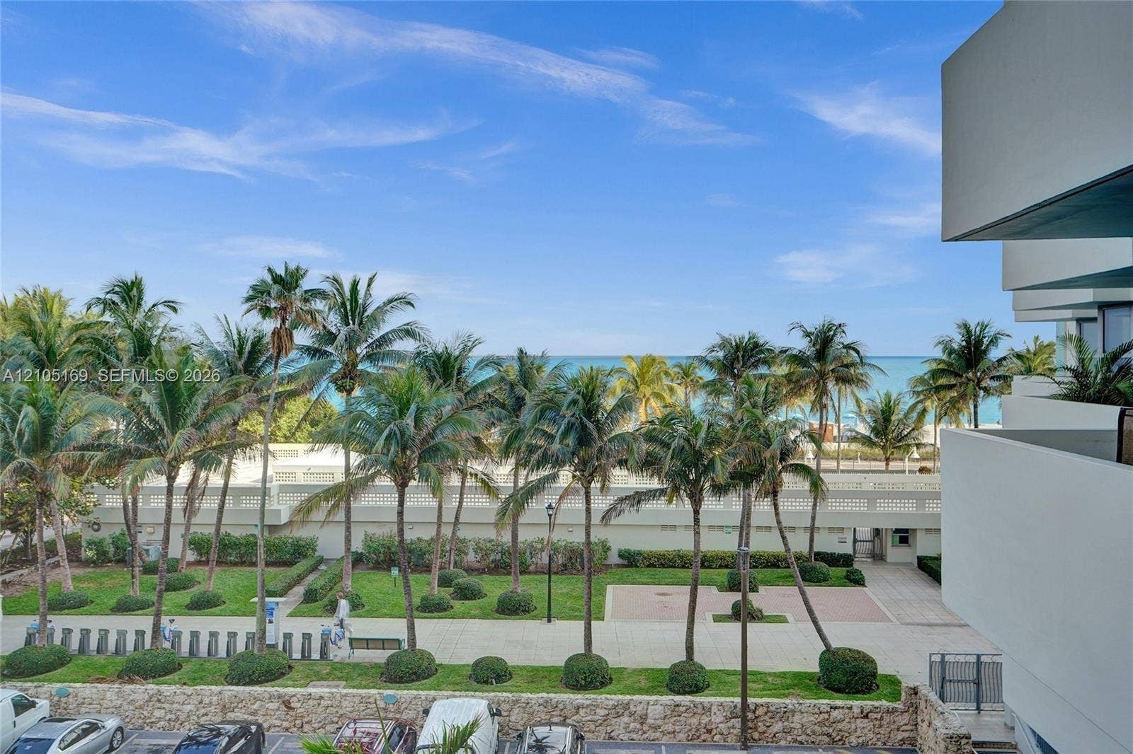 2899 Collins Avenue, #521, Miami Beach, FL 33140 Oceanfront setting featuring extensive palm trees, manicured lawns, and a clear blue sky