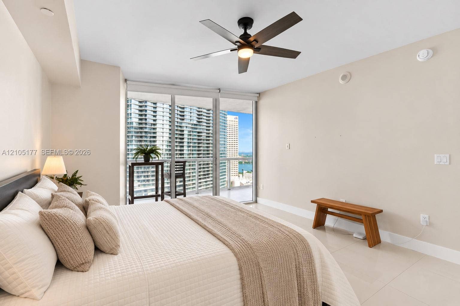 475 Brickell Avenue, #2414, Miami, FL 33131 Floor-to-ceiling glass sliding doors, polished tile flooring, ceiling fan with integrated lighting, and access to a private balcony