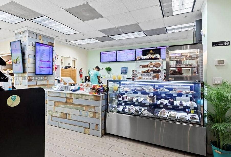 3801 S Ocean Drive, #10G, Hollywood, Hollywood, FL 33019 Commercial space featuring wood-plank paneled service counter, stainless steel refrigerated display case, drop ceiling with recessed lighting, and wood-finish tile flooring