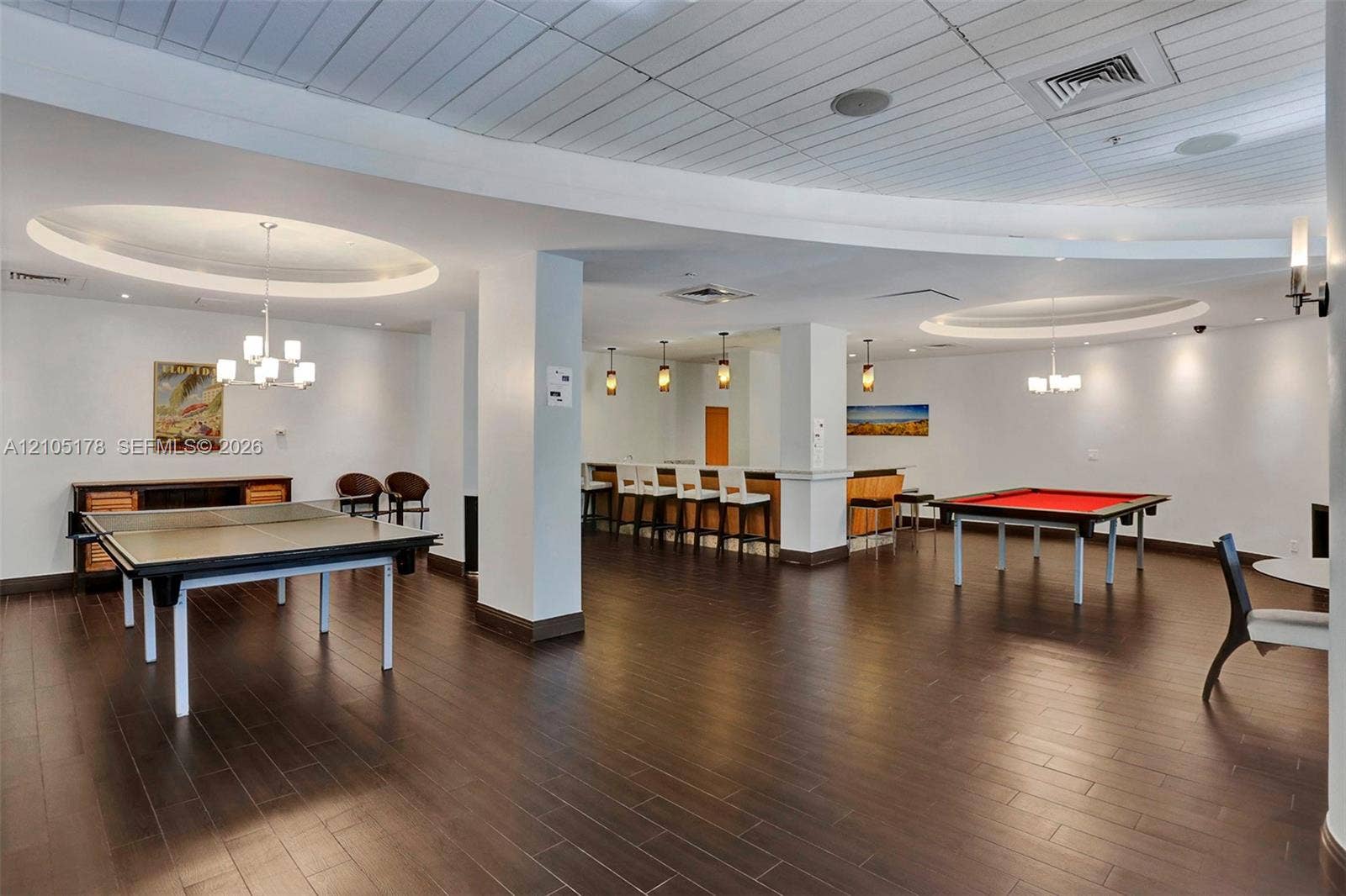3801 S Ocean Drive, #10G, Hollywood, Hollywood, FL 33019 Open-concept interior featuring wood-finish flooring, recessed circular tray ceilings with decorative light fixtures, and a built-in bar with pendant lighting