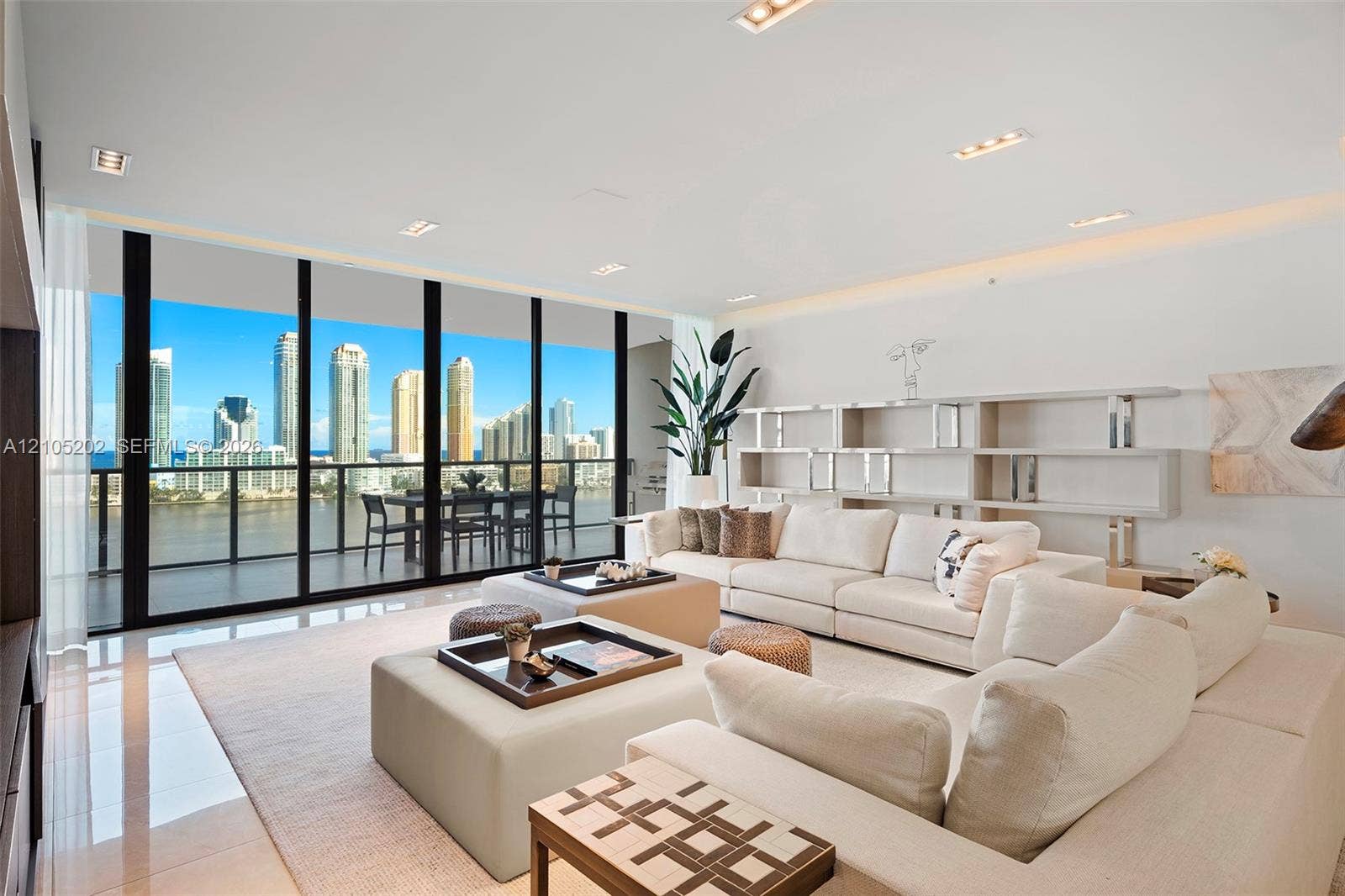 Floor-to-ceiling windows, polished tile flooring, built-in recessed shelving, recessed lighting, and a covered balcony
