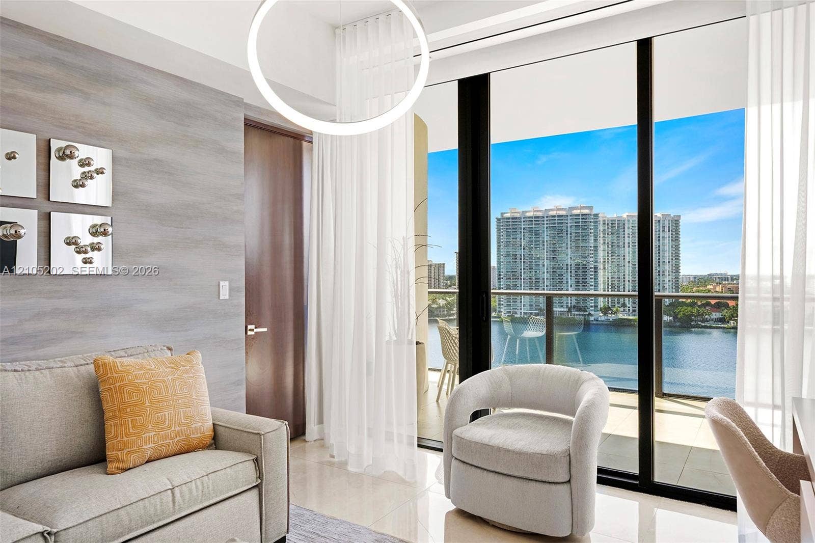 Floor-to-ceiling glass sliding doors, private balcony with metal railing, textured wall treatment, recessed ceiling lighting, and tile flooring