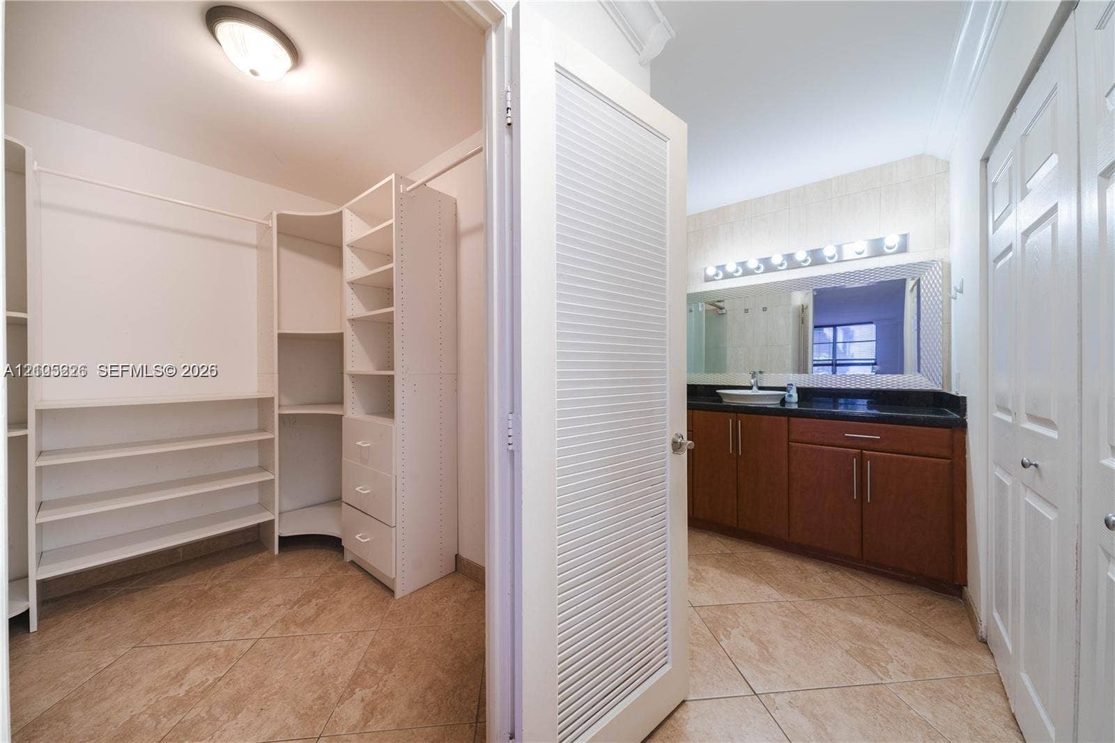 3800 S Ocean Drive, #801, Hollywood, Hollywood, FL 33019 Bathroom featuring a dark stone-finish countertop, wood-finish cabinetry, vessel sink, full-width mirror with integrated lighting, and a glass-enclosed shower and tub combination