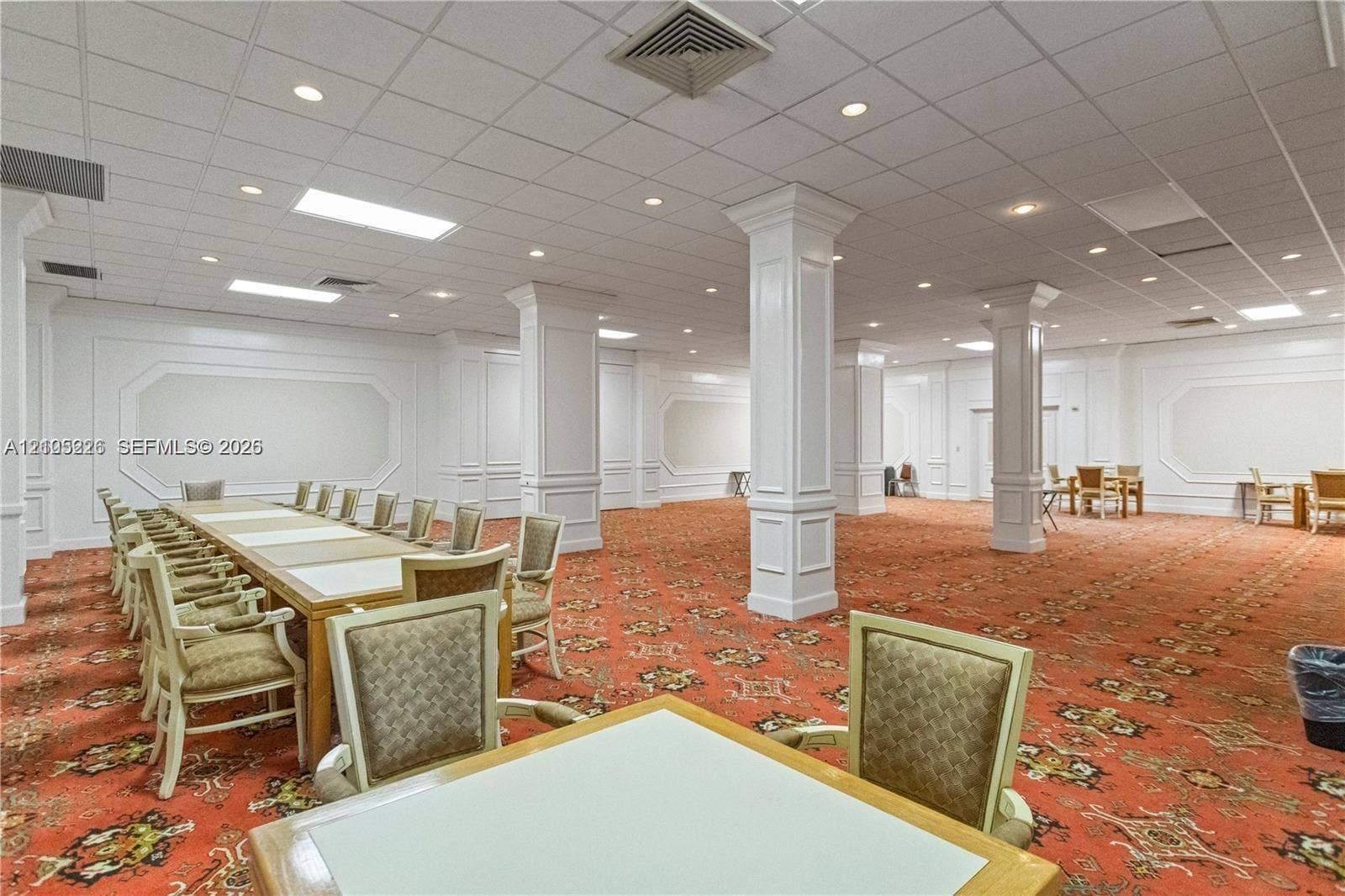 3800 S Ocean Drive, #801, Hollywood, Hollywood, FL 33019 Expansive open interior space featuring wood-finish parquet flooring, a raised stage with curtained backdrop, tray ceiling detailing, and dual chandelier fixtures