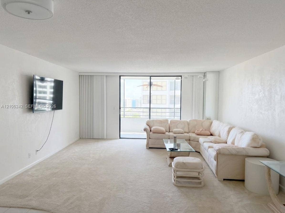 Recessed lighting in ceiling, neutral wall finish, wall-to-wall carpeting, floor-to-ceiling glass doors, and a private balcony
