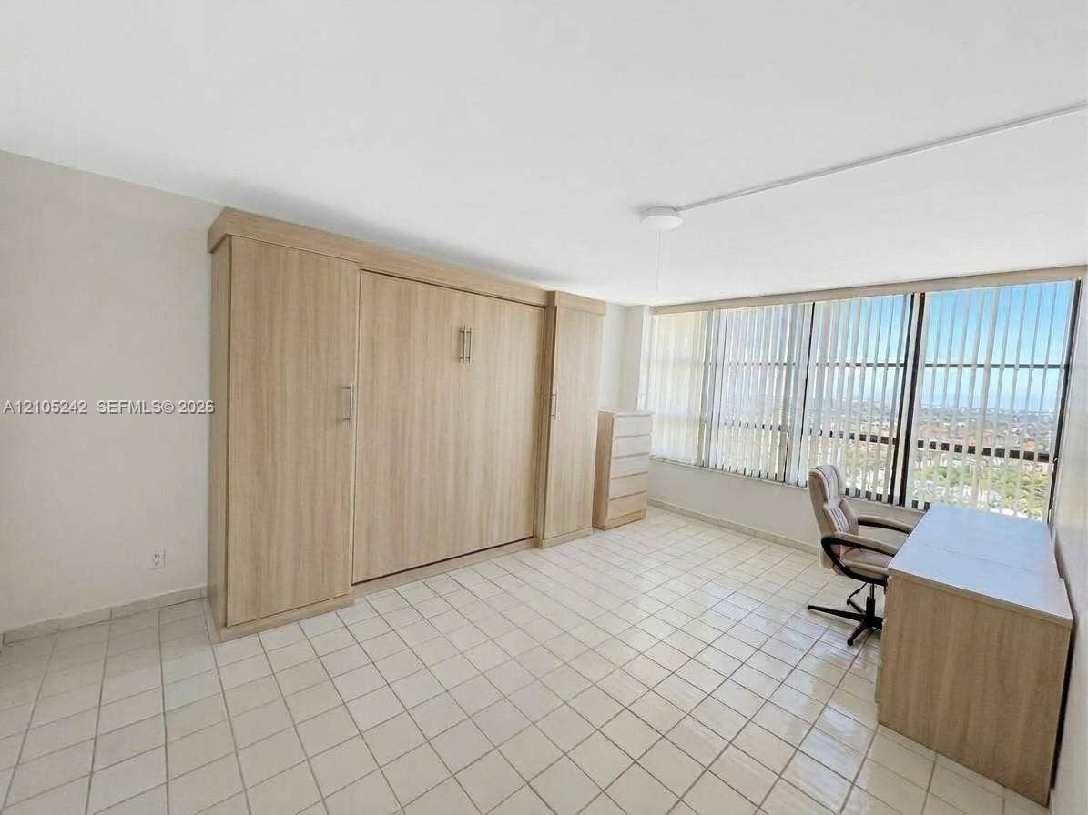 Built-in cabinetry with wood-finish, full-height windows with vertical blinds, tile flooring, and recessed ceiling lighting