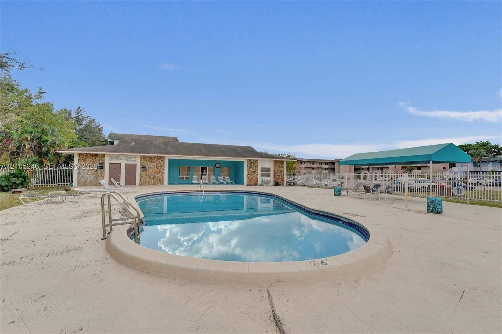 1400 Tallwood Avenue, #207, Hollywood, FL 33021 In-ground pool featuring a concrete deck, metal handrail, and shaded canopy area