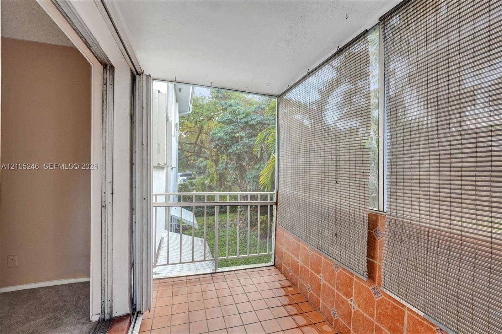 1400 Tallwood Avenue, #207, Hollywood, FL 33021 Screened-in balcony featuring tile flooring, half-wall tile detailing, metal railing, and sliding glass door access