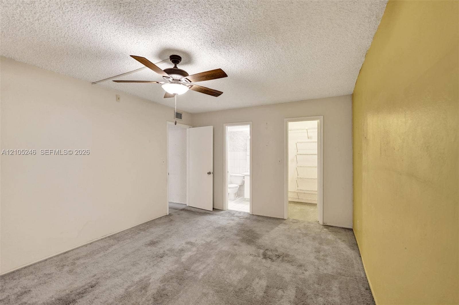 1400 Tallwood Avenue, #207, Hollywood, FL 33021 Interior space featuring neutral carpeting, a ceiling-mounted light fixture with fan, and built-in closet shelving