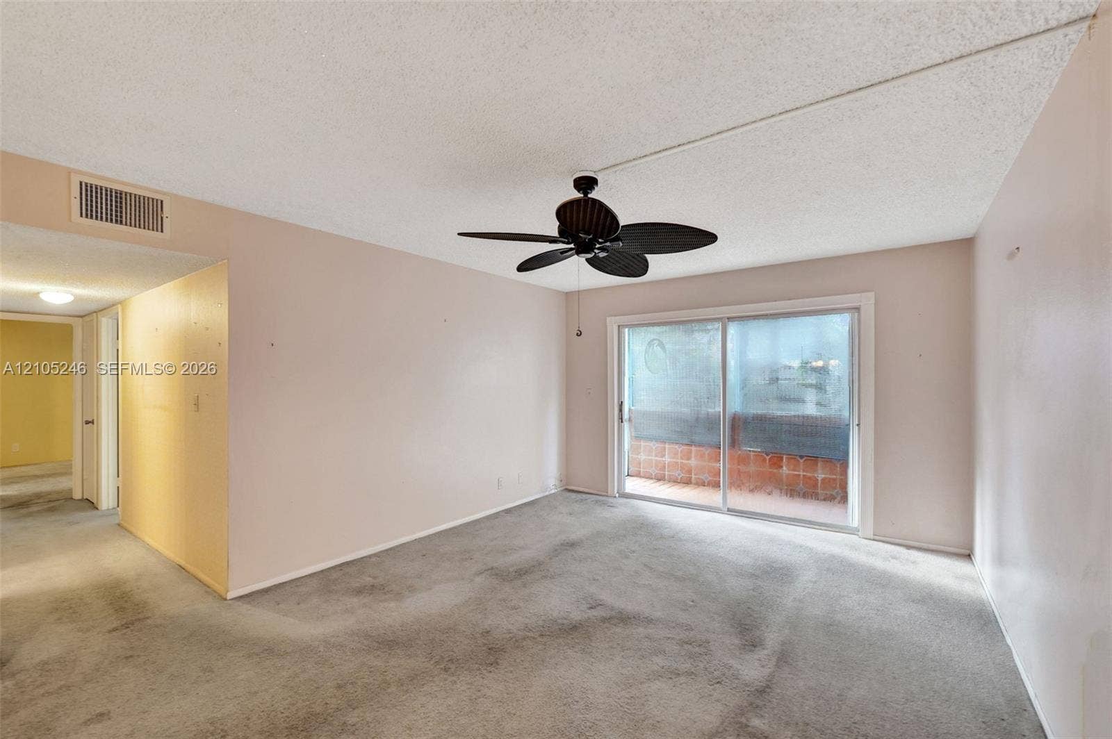 1400 Tallwood Avenue, #207, Hollywood, FL 33021 Interior space featuring sliding glass doors to a balcony, a ceiling-mounted fan, and carpeted flooring