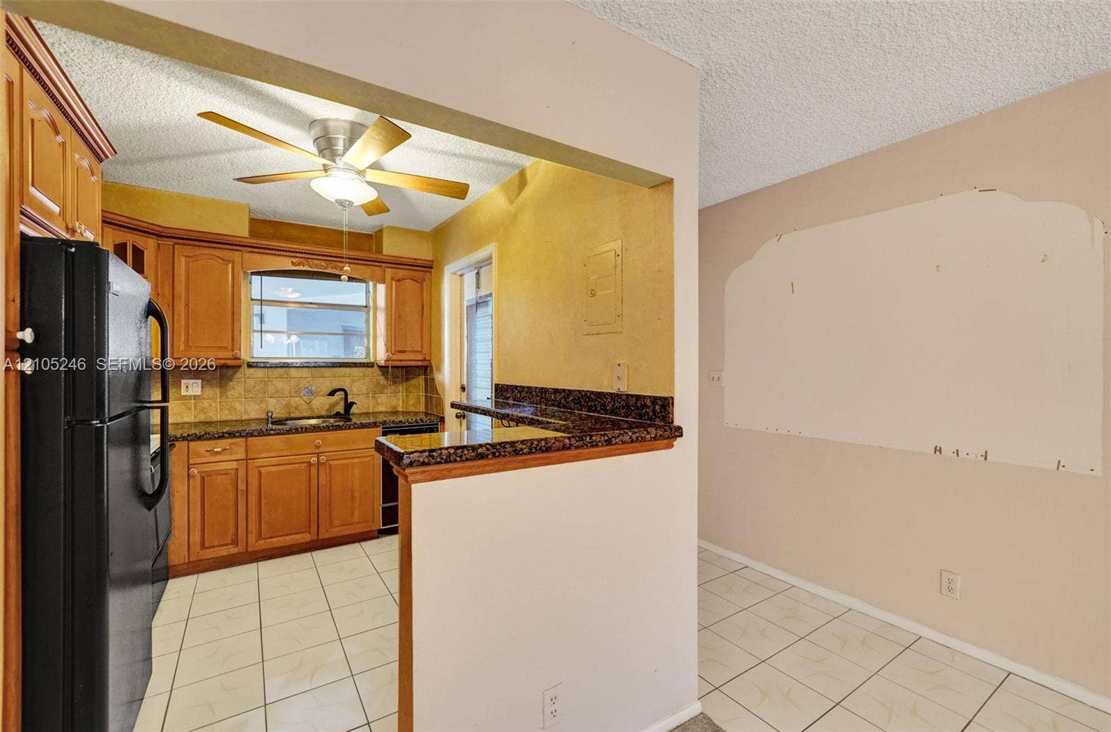 1400 Tallwood Avenue, #207, Hollywood, FL 33021 Kitchen featuring wood cabinetry, stone-finish countertops, a dual-basin sink with a matte black faucet, tile flooring, and a ceiling-mounted light fixture