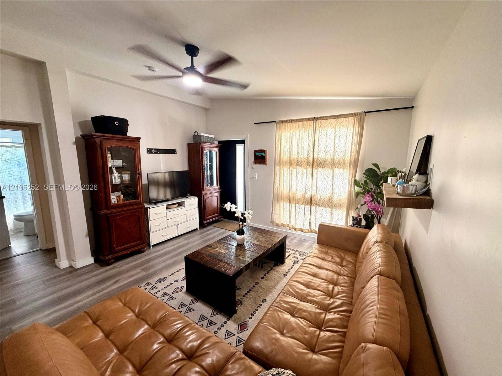 700 NW 17th Terrace, Pompano Beach, FL 33069 Expansive living area featuring a ceiling fan, wood-finish flooring, and natural light