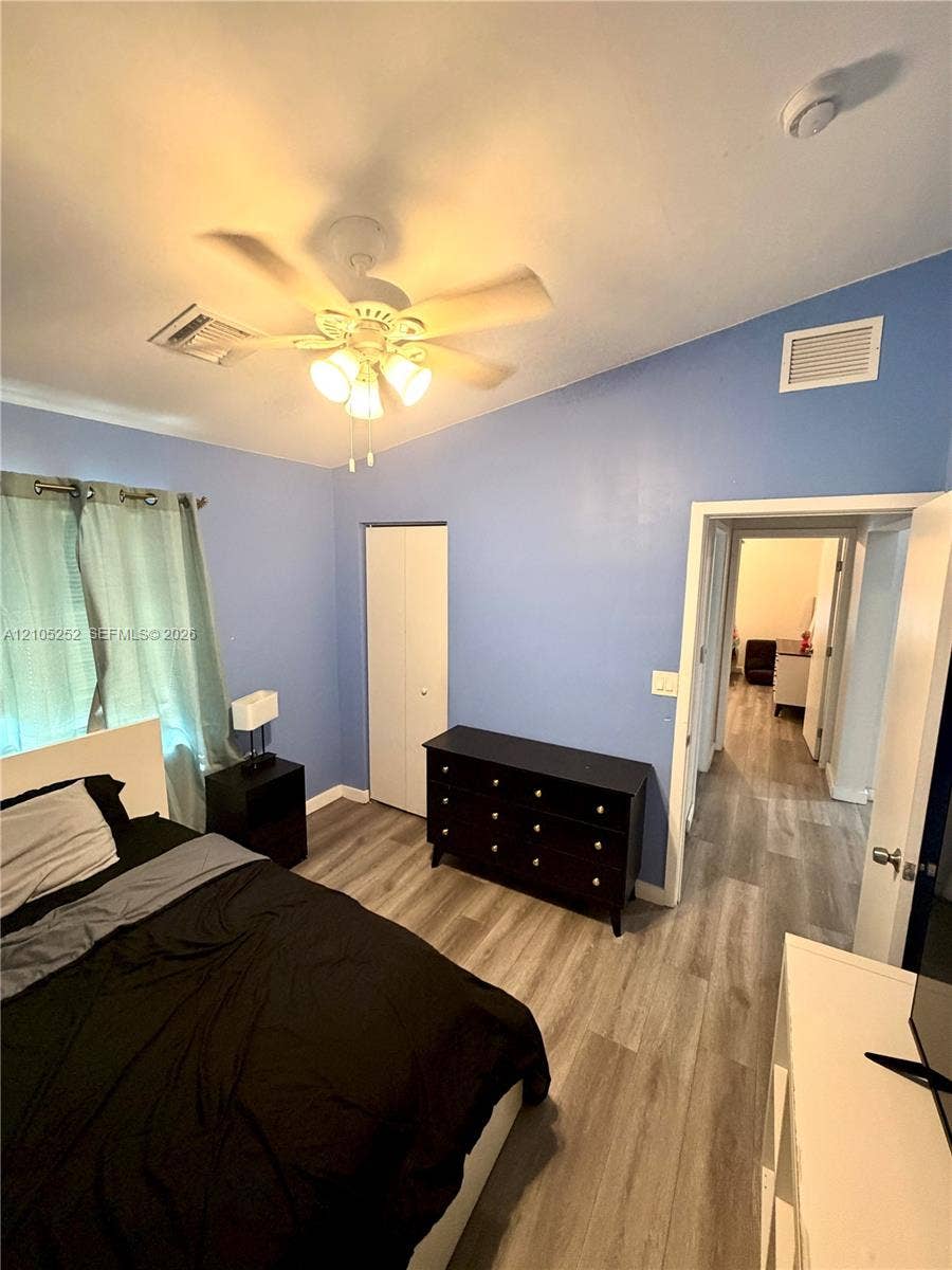 700 NW 17th Terrace, Pompano Beach, FL 33069 Vaulted ceiling with an attached ceiling fan, wood-finish flooring, and a built-in closet with bifold doors
