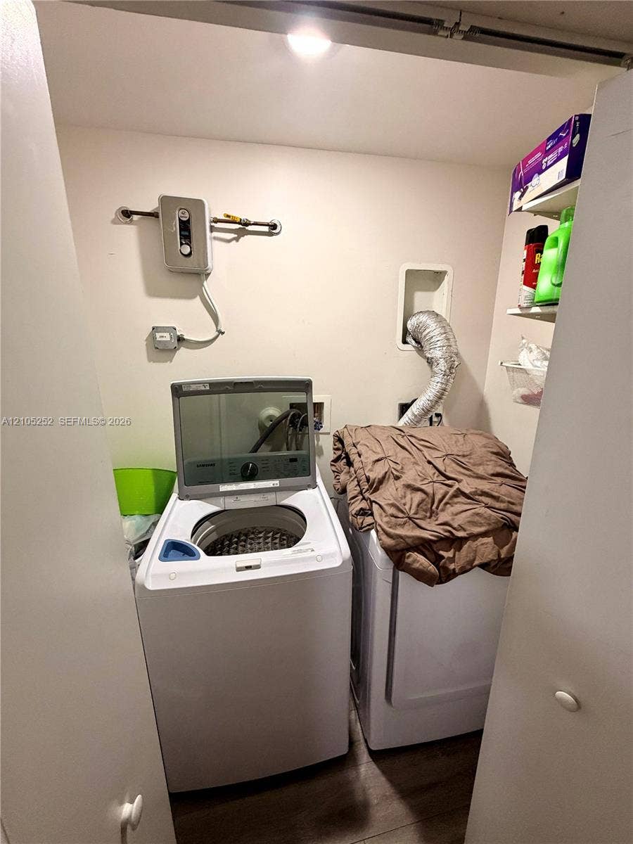 700 NW 17th Terrace, Pompano Beach, FL 33069 Dedicated laundry area with wood-finish flooring and built-in shelving