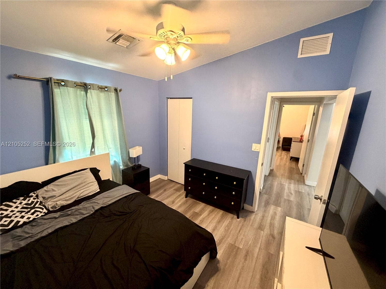 700 NW 17th Terrace, Pompano Beach, FL 33069 Vaulted ceilings with a ceiling fan, wood-finish flooring, and bi-fold closet doors