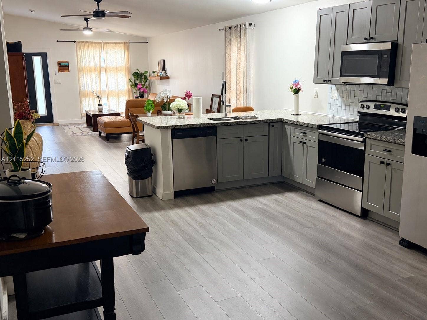 700 NW 17th Terrace, Pompano Beach, FL 33069 Kitchen featuring gray cabinetry, stainless steel appliances, and a light-colored backsplash