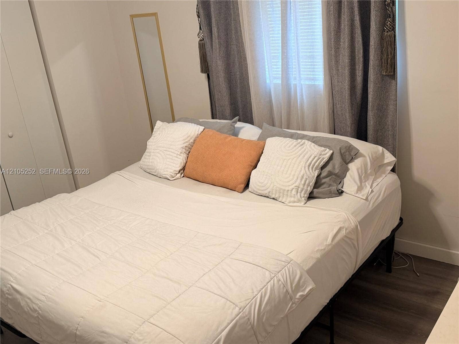 700 NW 17th Terrace, Pompano Beach, FL 33069 Wood-finish flooring with a window featuring blinds and drapes