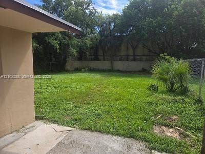 2208 Garfield Street, #B, Hollywood, Hollywood, FL 33020 Expansive green space featuring a concrete patio, perimeter fencing, and mature trees