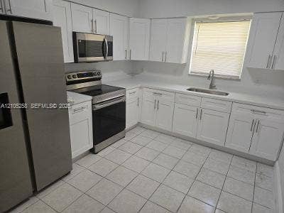 2208 Garfield Street, #B, Hollywood, Hollywood, FL 33020 White shaker cabinetry, stainless steel appliances, light-toned countertops, tile flooring, and an undermount sink with a gooseneck faucet
