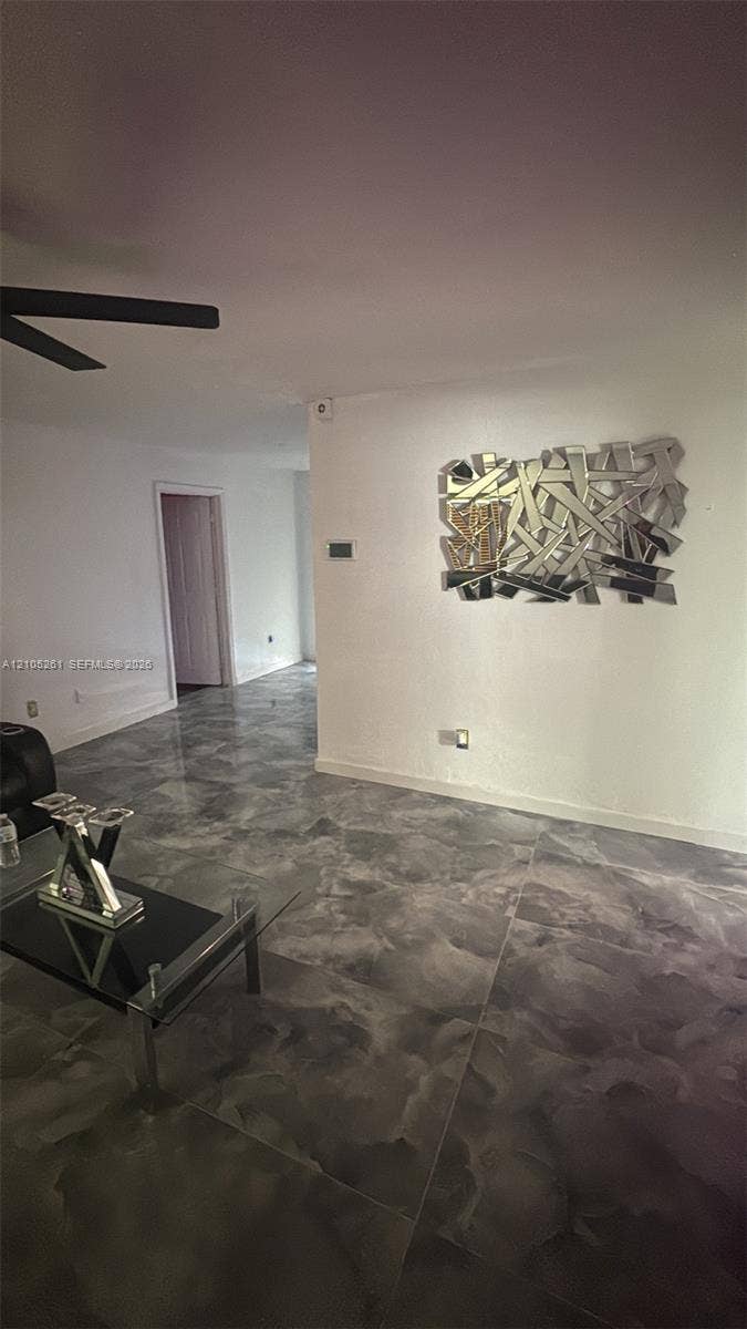 Polished concrete flooring, recessed wall lighting, and a ceiling fan with dark blades
