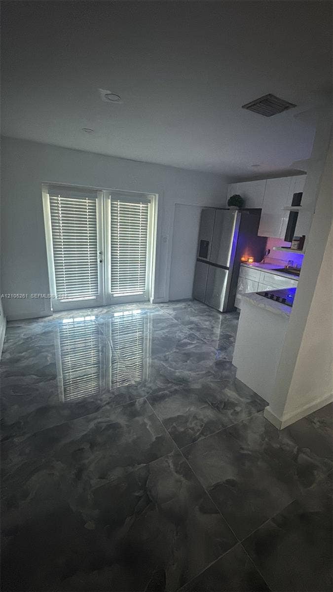 Glossy large format floor tiling, white French doors with integrated blinds, and recessed lighting