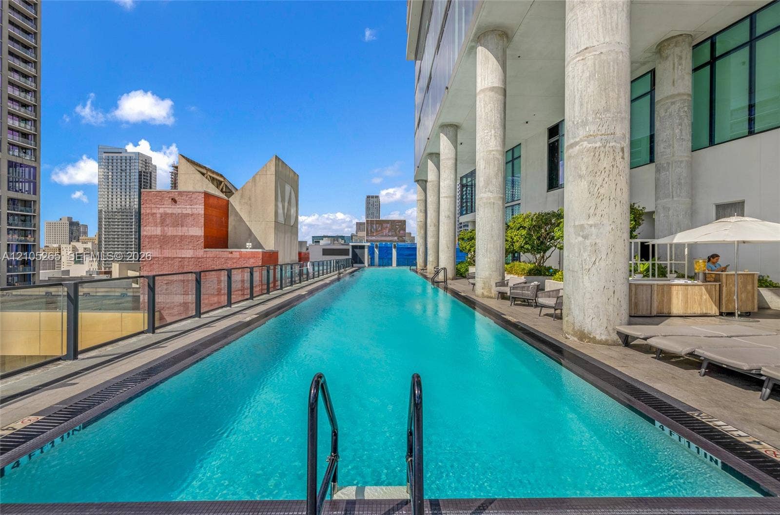 398 NE 5th Street, #2219, Miami, FL 33132 Lap pool with tile perimeter, structural concrete columns, and glass panel railing