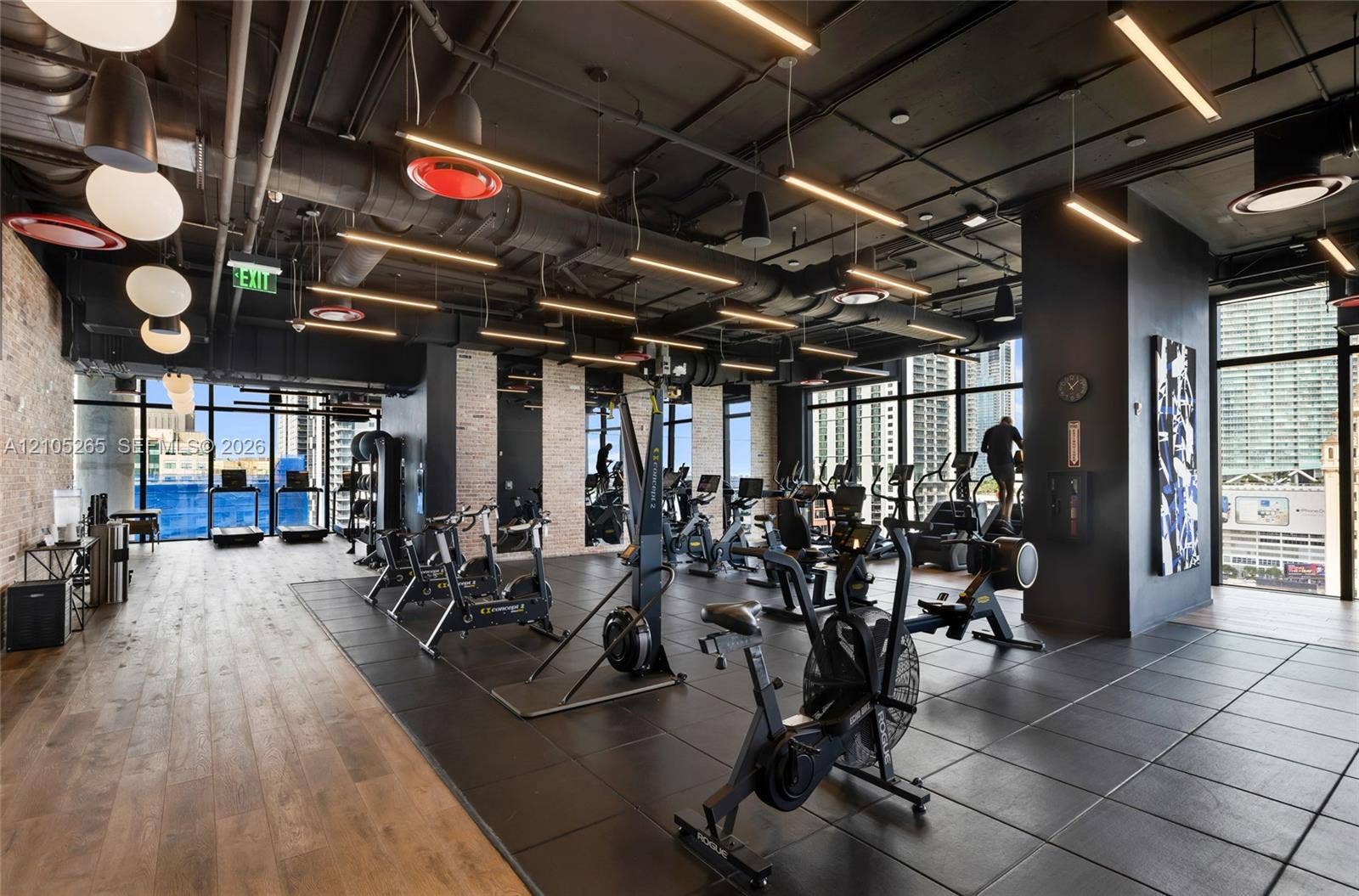 398 NE 5th Street, #2219, Miami, FL 33132 Fitness center featuring industrial-style exposed ceilings, wood-finish flooring, rubber matting, floor-to-ceiling windows, and linear LED lighting