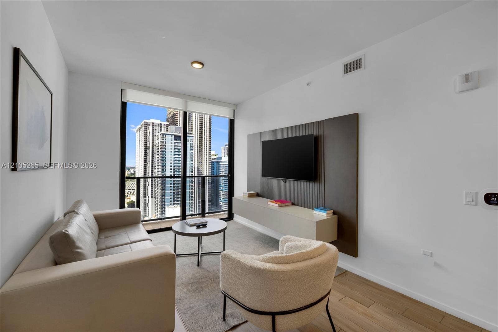 398 NE 5th Street, #2219, Miami, FL 33132 Floor-to-ceiling windows, wood-finish flooring, custom wall paneling, and a wall-mounted floating cabinet